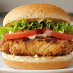 Saftiger Chicken Burger aus der Heißluftfritteuse mit knuspriger Kruste und frischem Gemüse.