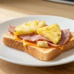 Leckeres Toast Hawaii aus der Heißluftfritteuse mit saftigem Schinken und geschmolzenem Käse.